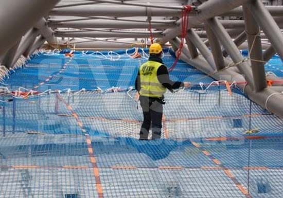 Trabajador en obra andando sobre redes transitables