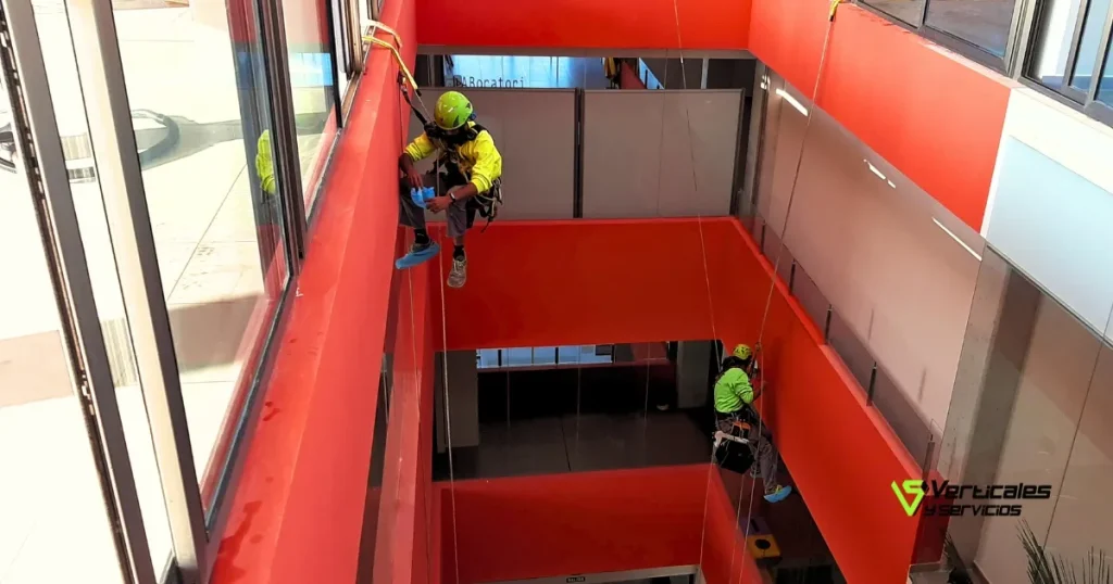 Operarios de Verticales y Servicios en un trabajo vertical en patio interior.