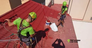 Operarios de Verticales y Servicios efectuando trabajos en altura sobre reparar un tejado de tejas.
