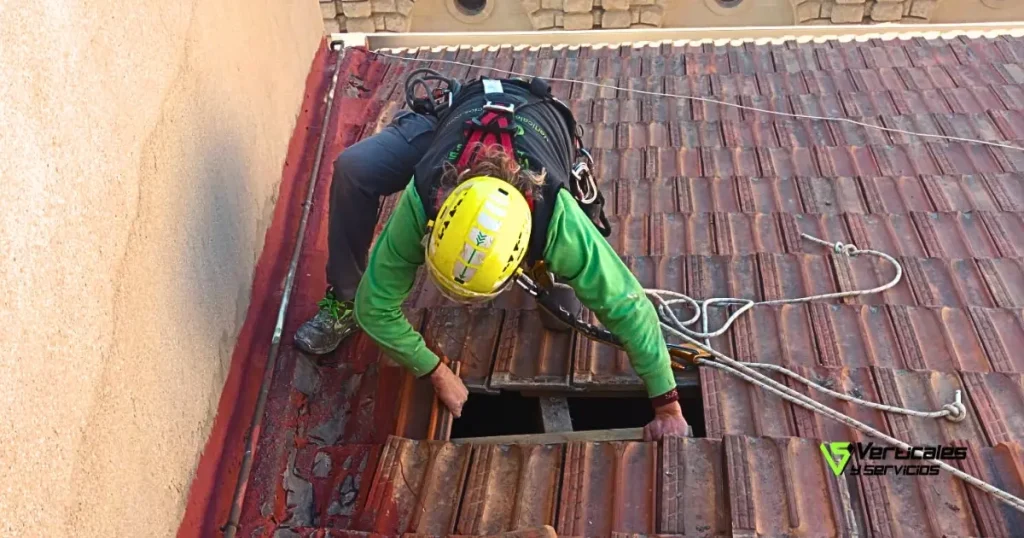 Operario de Verticales y Servicios durante la reparación de un tejado de tejas.