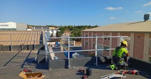 Operario de VyS en el que se está instalando medidas de protección colectiva frente a caídas en altura.