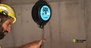 Infografía técnica que muestra la elongación de un absorbedor de energía (cota B) durante el proceso de frenado en una caída de altura.